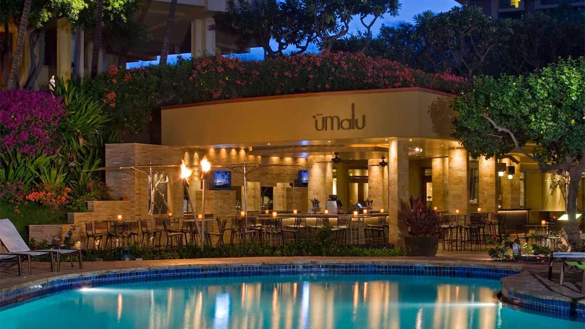 evening exterior view of outdoor pool with lights reflecting on water at the Hyatt Regency Maui Resort and Spa in Maui, Hawaii, USA